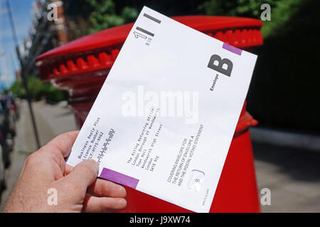 Großbritannien, London: Einem Postumschlag Abstimmung wird in eine Königliche Post-Briefkasten in London vor den Parlamentswahlen 2017 gebucht. Stockfoto