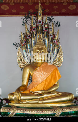 Eine farbige goldene Statue des Buddha sitzt in einem Schrein im Wat Pho, Bangkok, Thailand Stockfoto