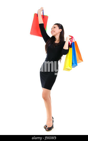 Asiatischen shopping Frau glücklich lächelnd hält viele Einkaufstaschen. Asiatische Shopper Mädchen isoliert auf weißem Hintergrund in voller Länge. Wunderschöne Mischlinge Kaukasier Southeast Asian Woman Modell. Stockfoto