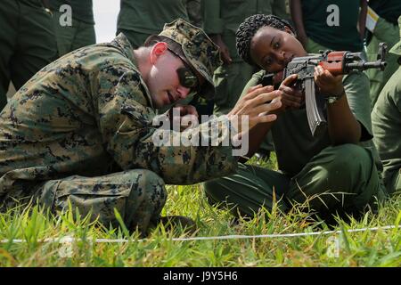 Ein US-Marine Soldaten veranschaulicht eine tansanische Parkwächter ein Sturmgewehr AKM aus einer sitzenden Position in das Selous Game Reserve Ziel 3. März 2015 in Matambwe, Tansania.    (Foto von Lucas J. Hopkins EURO1 Marines über Planetpix) Stockfoto