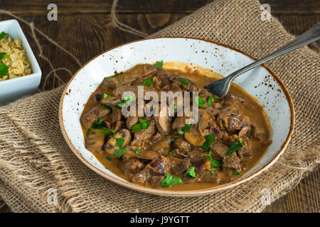 Rindfleisch und Pilz Strogonoff mit Reis auf Holztisch Stockfoto