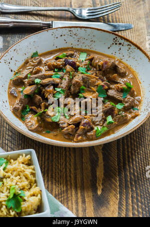 Rindfleisch und Pilz Strogonoff mit Reis auf Holztisch Stockfoto