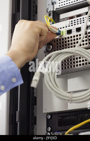 Mann, USB-Kabel im Datenserver im Data Center einfügen Stockfoto