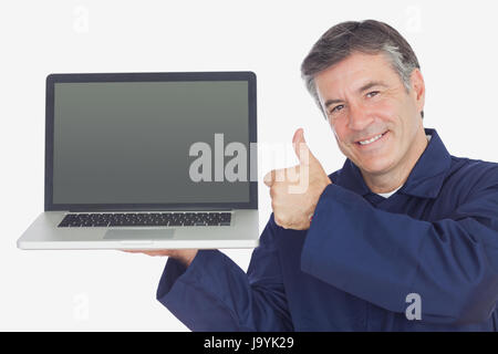 Porträt von glücklich Mechaniker mit Laptop zeigt Daumen hoch Zeichen vor weißem Hintergrund Stockfoto