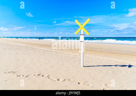 Holzstab mit gelben Kreuz unterzeichnen am Strand von Kampen an sonnigen Sommertag, Insel Sylt, Nordsee, Deutschland Stockfoto