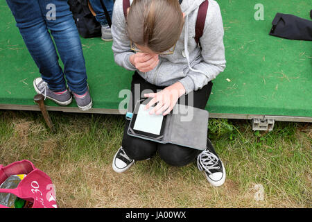 Ein Mädchen, das Lesen eines Buches auf ein Kindle bei Hay Festival, Hay-on-Wye, Wales UK KATHY DEWITT Stockfoto