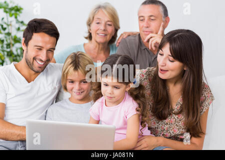 Lächelnde Familie gerade etwas am Laptop auf der couch Stockfoto