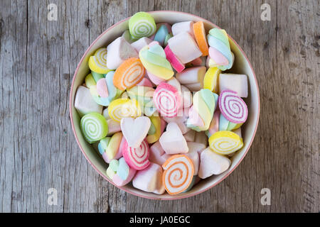 Nahaufnahme von bunten Mini Marshmallows mit Süßigkeiten in Schüssel auf Holztisch Hintergrund oder Textur. Textfreiraum Stockfoto