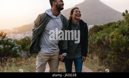 Porträt des Lächelns junges Paar Spaziergang durch Country Trail. Glücklicher junger Mann und Frau in der Natur Wandern und lächelnd. Stockfoto