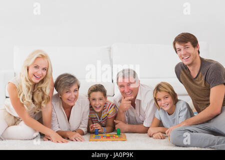 Familie mit Brettspielen im Wohnzimmer in die Kamera schaut Stockfoto