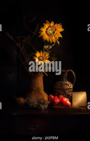 Stilleben mit Sonnenblumen, Birnen und Käse. Stockfoto