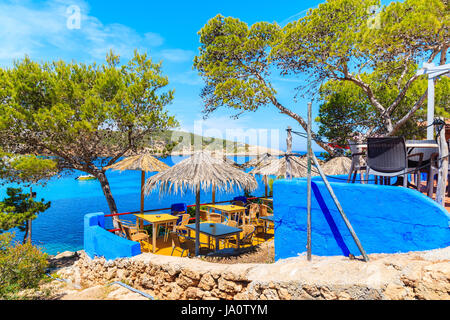 Insel IBIZA, Spanien - 16. Mai 2017: Kleine Küstenstadt Restaurant auf Klippe Felsen mit Pinien in Cala Portinatx Bucht, Insel Ibiza, Spanien. Stockfoto