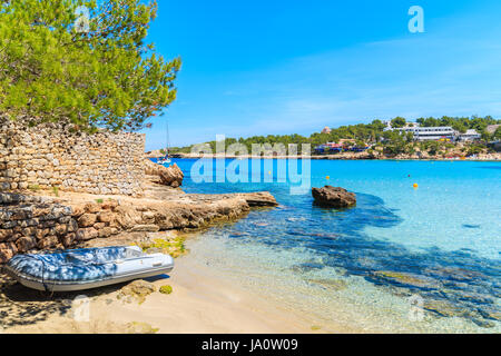 Jolle auf idyllischen Cala Portinatx Strand mit flachem kristallklarem Meerwasser, Insel Ibiza, Spanien Stockfoto