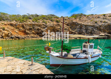 Weiße typischen Fischerboot ankern in wunderschönen Cala Carbo Bucht mit smaragdgrünes Meerwasser, Insel Ibiza, Spanien Stockfoto