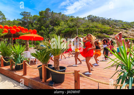 Insel IBIZA, Spanien - 17. Mai 2017: Junge Menschen tanzen auf der Terrasse des Restaurant am Strand in Cala Carbo, während sie gefilmt werden, um zu produzieren Stockfoto