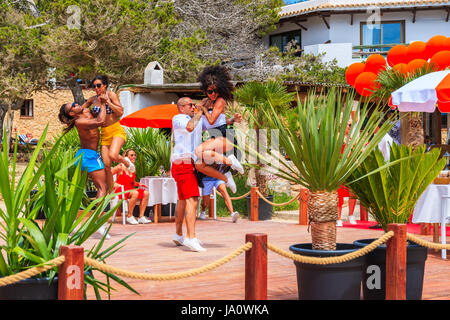 Insel IBIZA, Spanien - 17. Mai 2017: Junge Menschen tanzen auf der Terrasse des Restaurant am Strand in Cala Carbo, während sie gefilmt werden, um zu produzieren Stockfoto