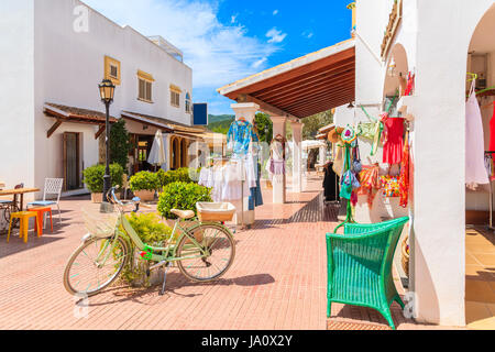 Grüne klassische Fahrrad dekoriert mit Frühlingsblumen auf Platz mit Shopes in Sant Carles de Peralta Dorf, Insel Ibiza, Spanien Stockfoto