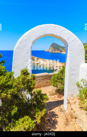 Weißer Bogen Tor auf Küstenpfad nach Punta Galera Bucht umgeben von erstaunliche Steinformationen, Insel Ibiza, Spanien Stockfoto