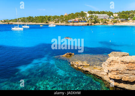 Touristen im Kajak paddeln auf dem blauen Meerwasser der Cala Portinatx Bucht, Insel Ibiza, Spanien Stockfoto