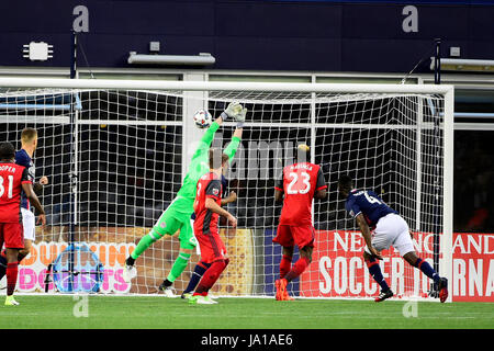 Foxborough, Massachusetts, USA. 3. Juni 2017. New England Revolution Verteidiger Angoua Brou Benjamin (4) trifft gegen Toronto FC Torhüter Alex Bono (25) während das MLS-Spiel zwischen Toronto FC und die New England Revolution statt im Gillette Stadium in Foxborough, Massachusetts. Zur Halbzeit der Revolution führen Sie Toronto FC 1: 0. Eric Canha/CSM/Alamy Live-Nachrichten Stockfoto