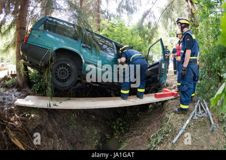 Holle, Deutschland. 4. Juni 2017. Helfer der deutschen Bundesanstalt für technische Hilfe (THW) abrufen, ein Auto, das durch einen Strom von Wasser im Sottrumer in der Nähe von Holle, Deutschland, 4. Juni 2017 mitgeführt wurde. Ein schweres Gewitter mit starkem Regen verursacht schwere Schäden in Teilen der Region Hildesheim Samstag nachts. Ein kleiner Bach in Sottrumer verwandelte sich in einen Strom von Wasser, trägt entfernt mehrere Autos. Foto: Julian Stratenschulte/Dpa/Alamy Live News Stockfoto