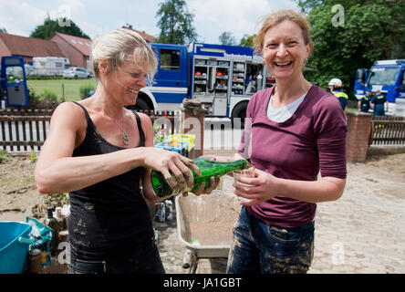 Holle, Deutschland. 4. Juni 2017. Einheimische trinken Sekt während der Aufräumarbeiten in Holle, Deutschland, 4. Juni 2017. Ein schweres Gewitter mit starkem Regen verursacht schwere Schäden in Teilen der Region Hildesheim Samstag nachts. Ein kleiner Bach in Sottrumer verwandelte sich in einen Strom von Wasser, trägt entfernt mehrere Autos. Foto: Julian Stratenschulte/Dpa/Alamy Live News Stockfoto