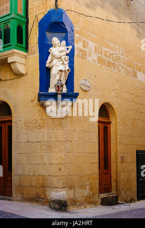 Fassade des traditionellen maltesischen Haus mit Nische an der Ecke dekoriert mit Statue der Muttergottes mit Kind Stockfoto