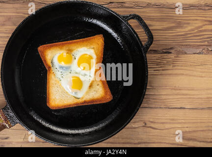 frittierte Wachteleier in einem Toast auf hölzernen Hintergrund Stockfoto