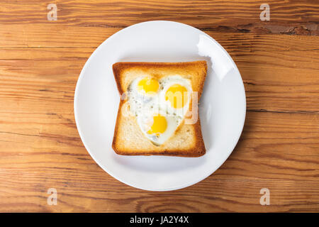 frittierte Wachteleier in einem Toast auf hölzernen Hintergrund Stockfoto
