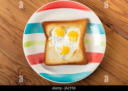 frittierte Wachteleier in einem Toast auf hölzernen Hintergrund Stockfoto