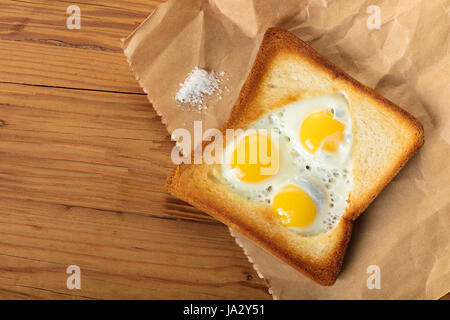 frittierte Wachteleier in einem Toast auf hölzernen Hintergrund Stockfoto