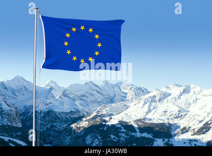 Verbund mit der Flagge der Europäischen Union flattern im Wind und Schnee bedeckt Berge im Hintergrund. Stockfoto