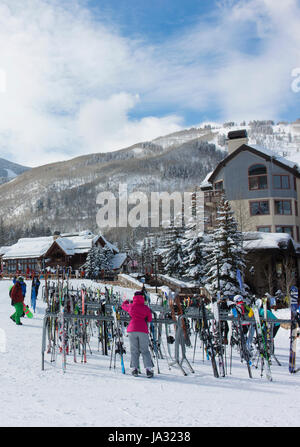 Ein Skifahrer kümmert sich um Ski zu einem Regal in Beaver Creek, einem Skigebiet in der Nähe von Avon, Colorado. Stockfoto