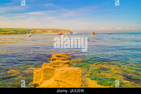 Swanage Felsenküste mit Boote in der Bucht Stockfoto