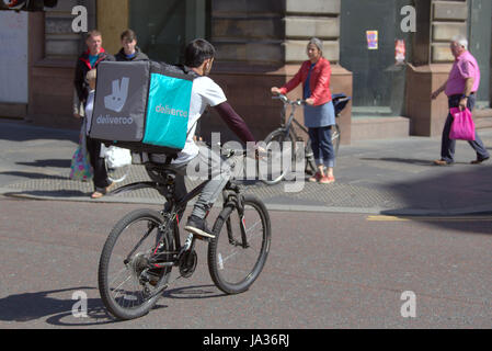 Deliveroo Uber Auslieferungsfahrer Biker Radfahrer auf der Straße nach Glasgow zu liefern Stockfoto