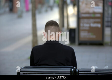 jungen Menschen sitzen auf einer Bank Ohren angesehen von hinten Stockfoto