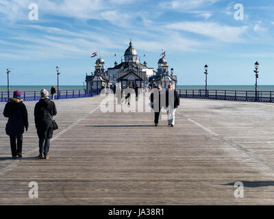 Besucher, die auf neuen Holzsteg Promenade von Eastbourne Pier an einem kalten Frühlingstag im März, East Sussex, England, UK. Stockfoto