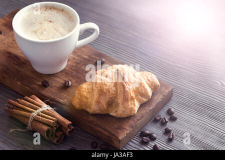 Kaffee mit Croissant zum Frühstück. Französische Croissants und Cappuccino Kaffee, Tönung Bild. Stockfoto