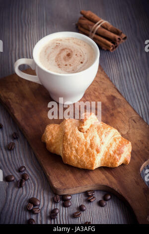 Kaffee mit Croissant zum Frühstück. Französische Croissants und Cappuccino Kaffee, Tönung Bild. Stockfoto