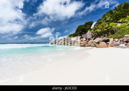 Perfekte weiße Strand Petite Anse in La Digue, Seychellen mit Granitfelsen und Palmen Stockfoto