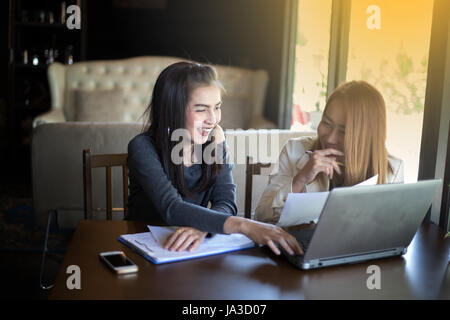 Zwei asiatische Geschäftsfrauen mit Notebook arbeiten und Diskussion über die wichtigen Auftrag im Büro, soft-Fokus Stockfoto