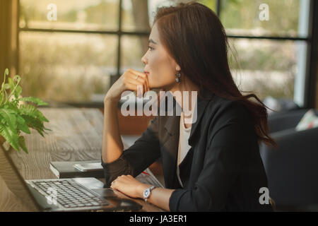Asiatische Geschäftsfrau ernsthaft die Arbeit getan, bis die Kopfschmerzen, soft-Fokus Stockfoto