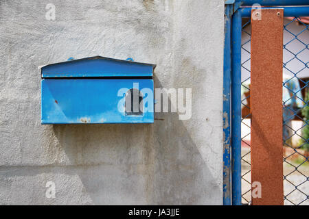 blauen Briefkasten vor der alte Betonmauer von zu Hause Stockfoto