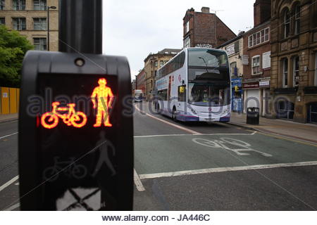 Rotes Licht an einem Fußgängerüberweg in Manchester als ein Stadtbus nähert. Stockfoto