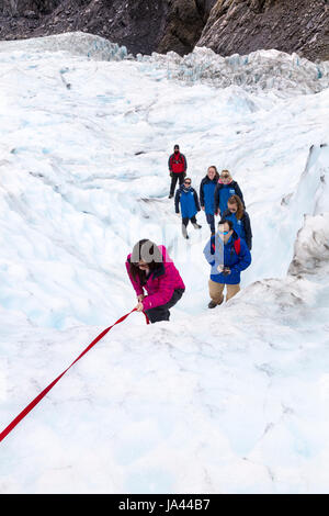 Gruppe von Menschen zu Fuß auf einem Gletscher (Fox Glacier, Südinsel, Neuseeland) Stockfoto