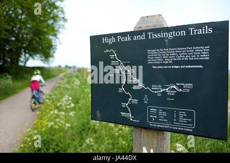 Ein Mädchen-Zyklen auf dem High Peak Trail in Derbyshire mit einem Schild mit einer Karte in den Vordergrund. Stockfoto