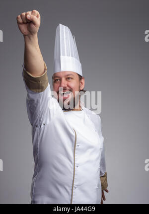 Bärtige Koch Mütze mit Freude schreit und zieht seine Hand nach vorne Stockfoto