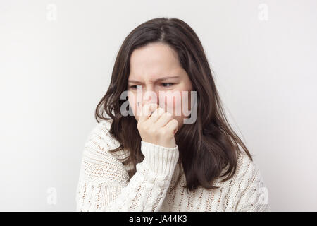 Mädchen mit langen Haaren steckt ihre Nase wegen widerlichen Geruch Stockfoto