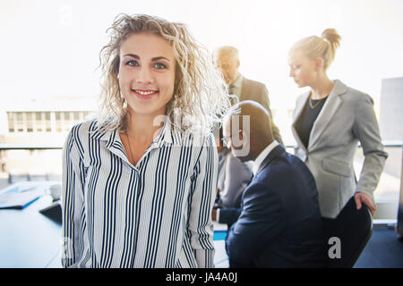 Business-Frau stand vor Team lächelnd, gemischte Unternehmerteam Stockfoto