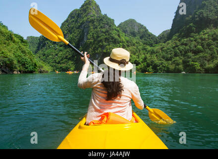 Mädchen, Kajakfahren auf dem Meer der Halong-Bucht in Vietnam Stockfoto